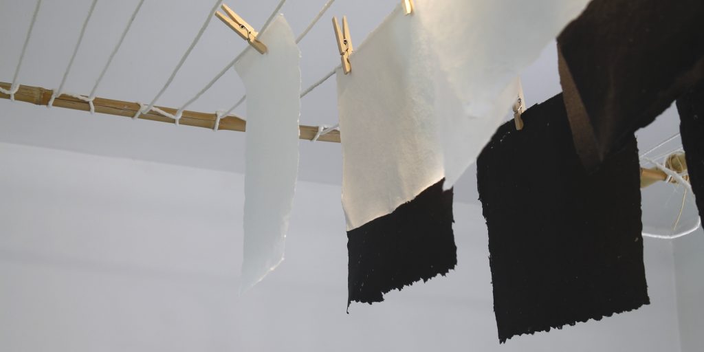 Papeles de algodón blanco y negro colgados en el tendal